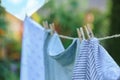 Washing line with drying shirts against blurred background, focus on clothespin Royalty Free Stock Photo