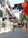 Washing lines with clothes over the narrow street called CALLE i Royalty Free Stock Photo