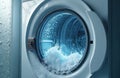Washing machine drum with water splashing. Bubbles and droplets create motion and dynamic waves inside the appliance during Royalty Free Stock Photo