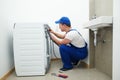 Washing machine installation or repair. plumber connecting appliance Royalty Free Stock Photo