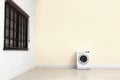 Washing machine near color wall in empty room. Laundry day Royalty Free Stock Photo