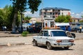 Washing machine placed on an old and rusty VAZ 2106 Zhiguli Soviet car roof rack , a traditional form of transportation of various