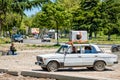 Washing machine placed on an old and rusty VAZ 2106 Zhiguli Soviet car roof rack , a traditional form of transportation of various