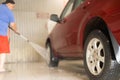 After washing, the man covers the car with protective wax. The driver washes the car after a long drive with foam and Royalty Free Stock Photo