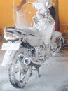 Washing a motorbike using a snow spray is easier and more practical Royalty Free Stock Photo