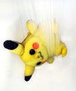 Washing a plush toy under the shower. Pokemon Pikachu, cute animated cartoon character