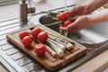 washing red tomatoes and asparagus for fresh dinner Royalty Free Stock Photo