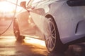 Washing rims at a manual car wash during sunset Royalty Free Stock Photo