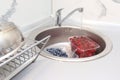 Washing ripe sweet cherry and blueberry in a kitchen sink under water jet, cleaning fresh juicy fruits in plastic containers of