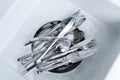 Washing silver spoons, forks and knives in kitchen sink with foam, flat lay Royalty Free Stock Photo