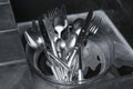 Washing silver spoons, forks and knives in kitchen sink with foam, above view Royalty Free Stock Photo