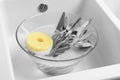 Washing silver spoons, forks and knives in kitchen sink Royalty Free Stock Photo