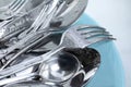 Washing silver spoons, forks and knives with plate, closeup