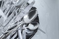 Washing silver spoons, forks and knives under stream of water in kitchen sink, flat lay. Space for text Royalty Free Stock Photo