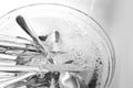 Washing silver spoons, forks and knives under stream of water in kitchen sink, above view Royalty Free Stock Photo