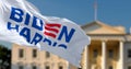 Biden Harris flag waving with blurred White House in the background