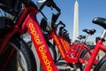 Capital Bikeshare bike rentals lined up with the Washington Monument in the background. These bikes