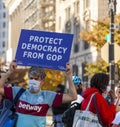 A man shows a banner that says Protect Democracy from GOP