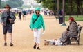 Washington DC, USA - June 9, 2019: Visitors to DC go for a stroll along the national mall. A homeless person sits on the bench at Royalty Free Stock Photo