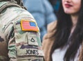 Flag of United States Marine Corps, USA or US army and symbols on an uniform of a soldier talking with a beautiful girl