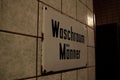 Washroom men sign on a tile-walled surface, closeup shot Royalty Free Stock Photo