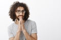 Wasit-up shot of handsome flirty bearded male with curly hair, looking aside and smirking, wearing glasses with striped