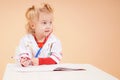 The child doctor sits at the desk and listens to the patient.