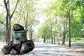 Waste bin green recycle and garbage plastic bags at beside walk way road, many trash plastic bags on street ground floor at park Royalty Free Stock Photo