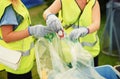 Waste, cleaner and people outdoor with a trash bag to recycle, garbage or beer can at festival. Volunteer, cleaning or Royalty Free Stock Photo