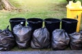 Waste, garbage in black bag and bin, pile of bin trash junk dirt and garbage bag many in garden public park, plastic waste