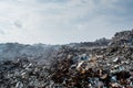 Waste at the garbage dump full of smoke, litter, plastic bottles,rubbish and trash at tropical island Royalty Free Stock Photo