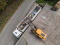 Waste loading operation, loader dumping trash in a truck, drone shot