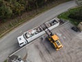 Waste loading operation, loader dumping trash in a truck, drone shot