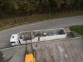 Waste loading operation, loader dumping trash in a truck, drone shot