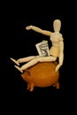 waste of money wooden mannequin piggy bank black background Royalty Free Stock Photo