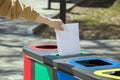 Waste separate collection and recycling, sorting garbage in different trash bins. Female hand throwing empty sheet of paper into Royalty Free Stock Photo