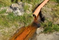 A waste water drainage pipe with flowing water polluting the environment Royalty Free Stock Photo