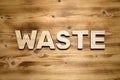 WASTE word made of wooden letters on wooden board