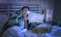 Wasted man sick at home freezing in bed covered with blanket sniffing sneezing and blowing nose suffering grippe feeling unwell Royalty Free Stock Photo