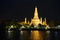 Wat Arun temple at night time with glitter light on the water
