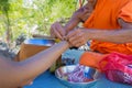 A monk tied holy thread on wrist of traveler. AT Wat Ban Tham Temple,Thailand