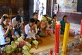 Praying family in temple with lotus flowers as Offerings at Wat Phnom Temple, Phnom Penh, Cambodia