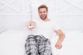 Watch morning show. man watch tv. change channel by remote control in bed. Rest at the hotel. happy man in pajama with Royalty Free Stock Photo