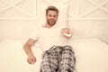Watch morning show. man watch tv. change channel by remote control in bed. Rest at the hotel. happy man in pajama with Royalty Free Stock Photo