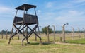 The watch tower and the barbed wire fence at the concentration camp Auschwitz II - Birkenau, Poland. Royalty Free Stock Photo