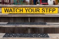 Watch your Step sign on a wooden set of stairs Royalty Free Stock Photo