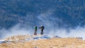 A young couple take a break to watch the beautiful valley beneath Hasmasu Mare mountains in Romania