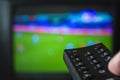 Watching football game and holding television remote control Royalty Free Stock Photo