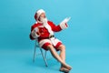 Full-length portrait of senior man wearing Santa Claus costume, holding glass of lager foamy beer isolated over blue Royalty Free Stock Photo