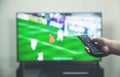 Watching football match on tv with remote controller. Royalty Free Stock Photo